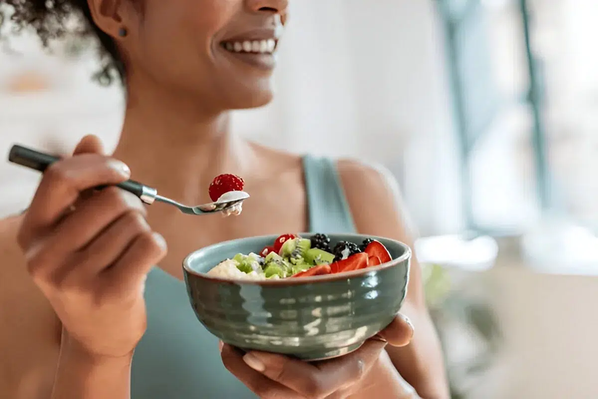 A person enjoying a healthy breakfast with a bowl of fresh fruits and yogurt - healthy breakfast ideas.