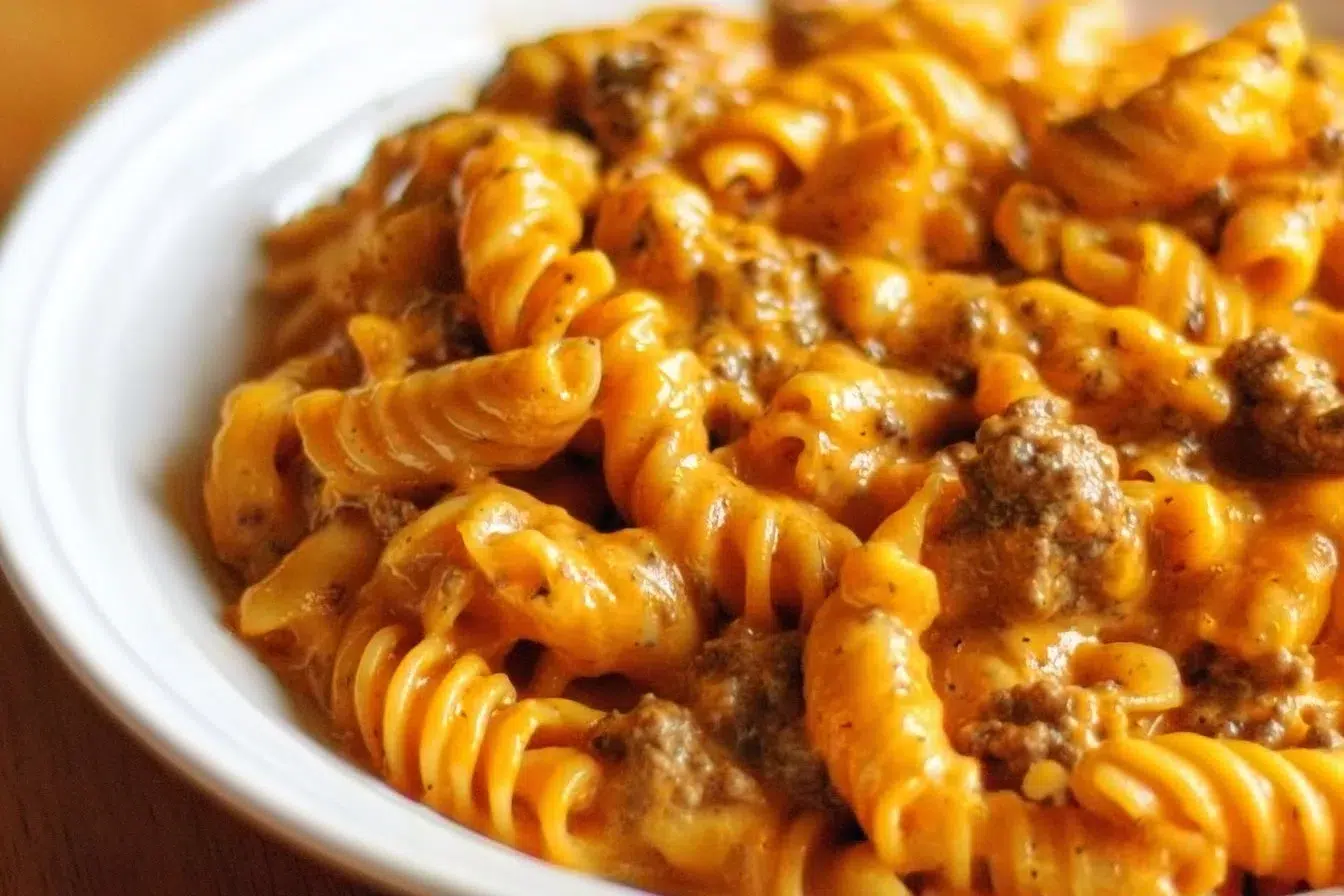 Creamy cheesy pasta with ground beef in a bowl topped with cheese