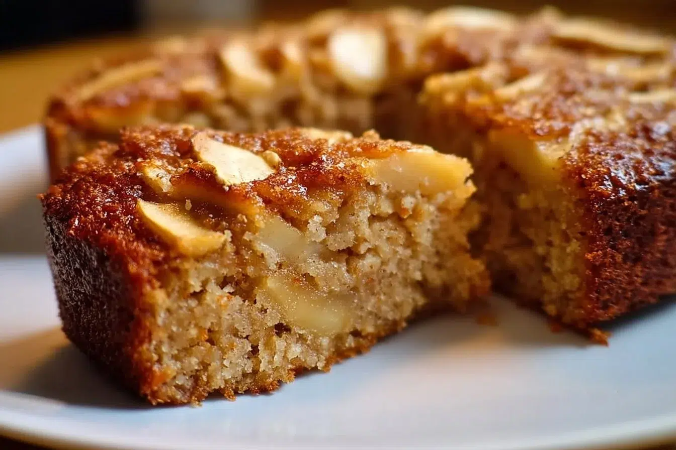 Slice of healthy oatmeal apple cake topped with fresh apples and oats