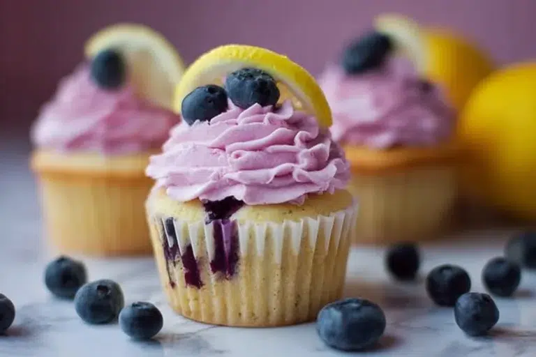 Lemon cupcakes with blueberry buttercream frosting on a decorative plate