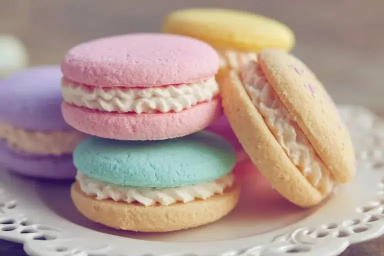 Colorful pastel sugar cookie sandwiches filled with cream and sprinkles